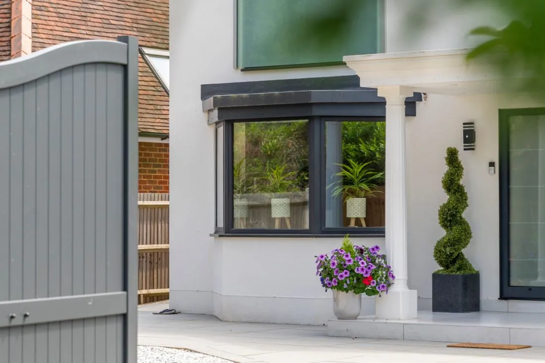 Grey AluK 58BW HI casement windows on a white rendered house