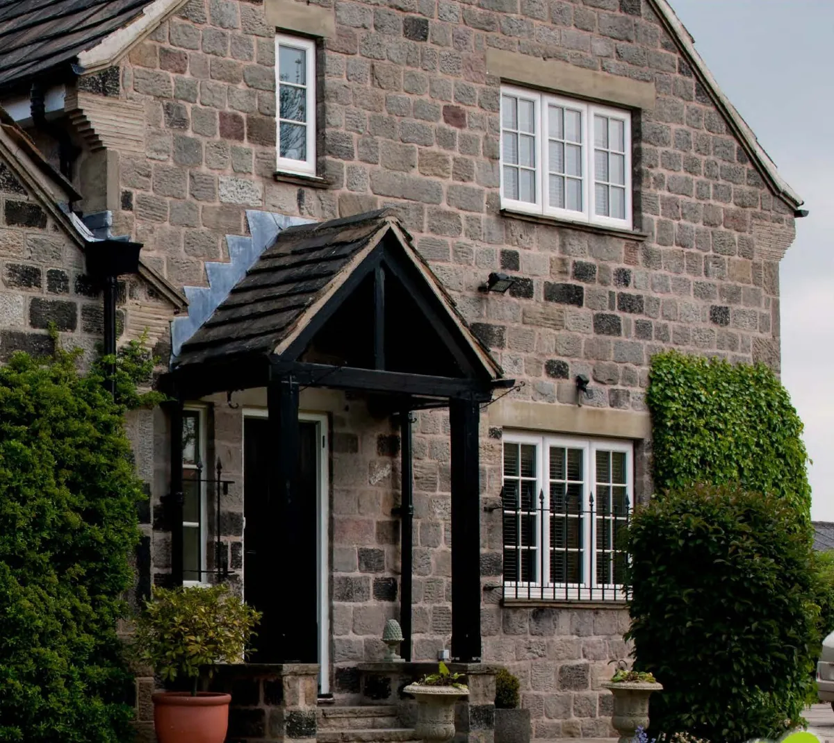 White Liniar casements with bars on a stone cottage